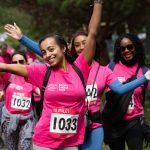Participants smiling, wearing bright pink Breast Cancer Now fundraising t-shirts