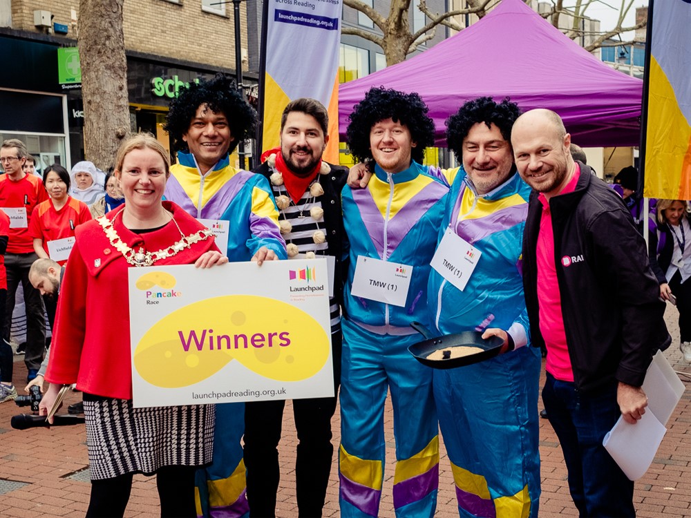 Launchpad's annual pancake race raises almost £8,000 as teams batter it out for glory.